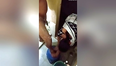 A beautiful brunette is getting a handjob on the bed